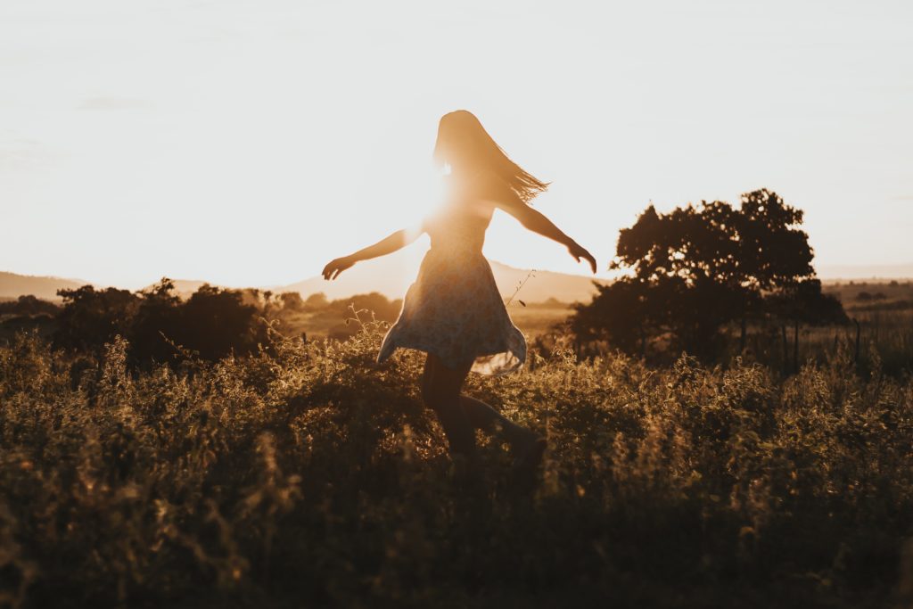 Silhouette of woman spinning and dancing before the sunset