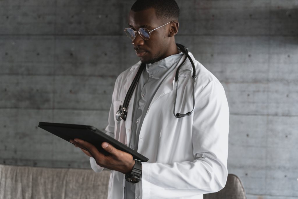 Doctor in white lab coat holding iPad