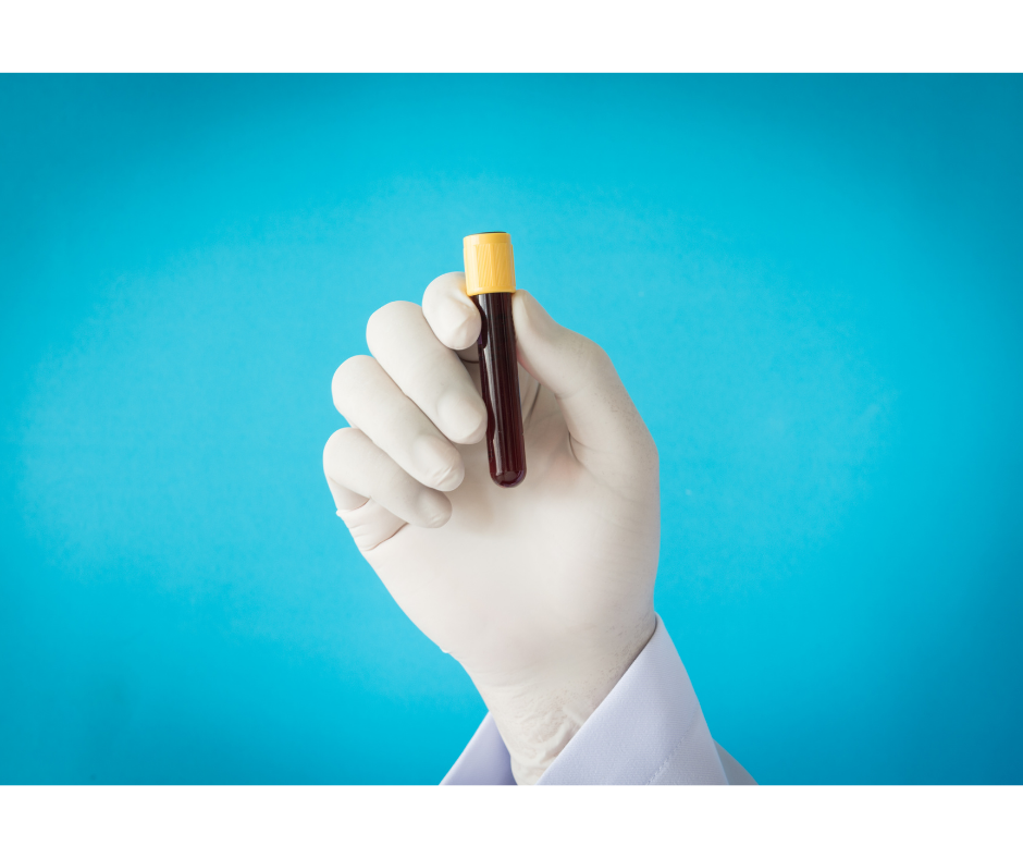 Gloved hand holding test tube of blood against blue background