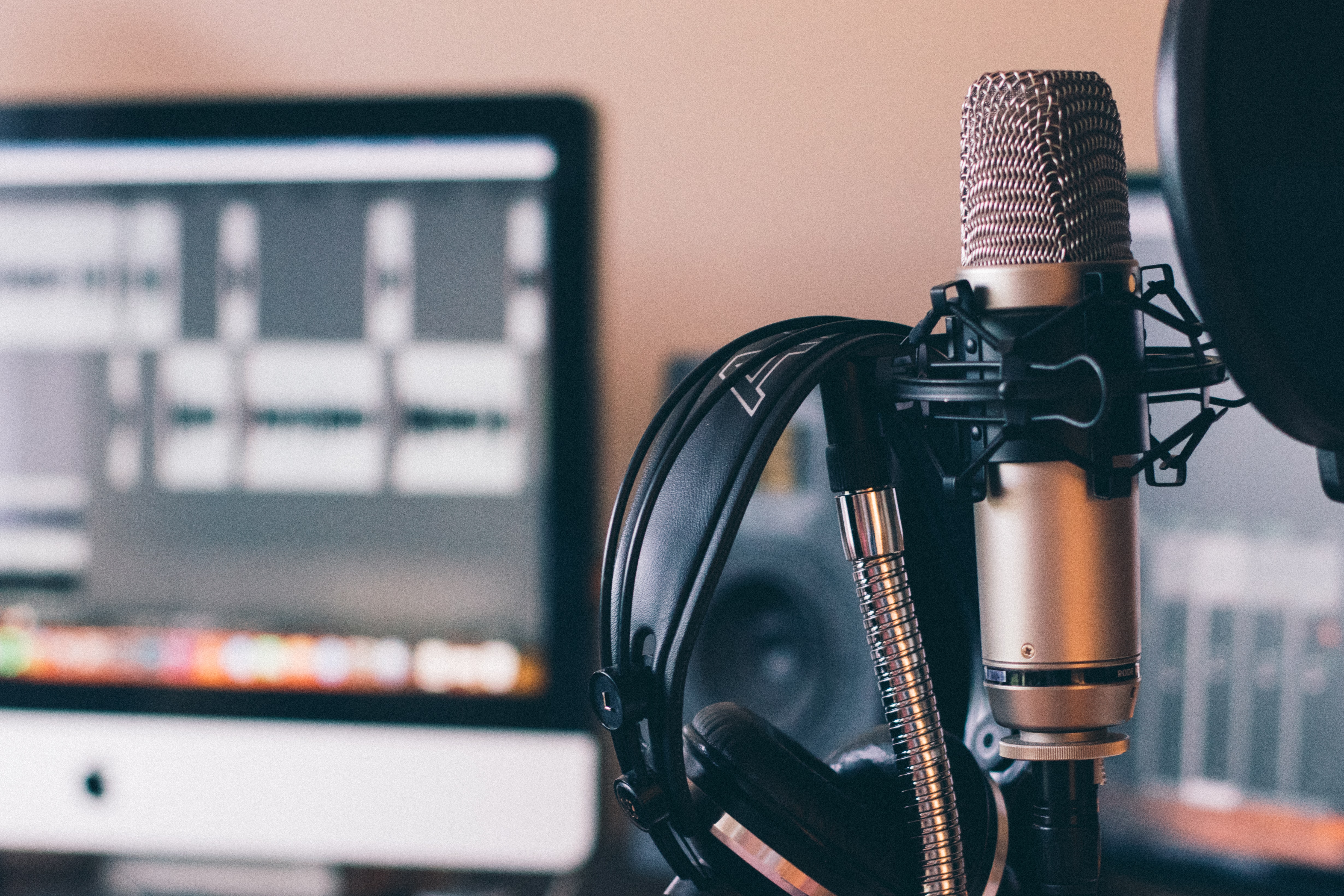 Podcast mic and headphones sitting in front of laptop