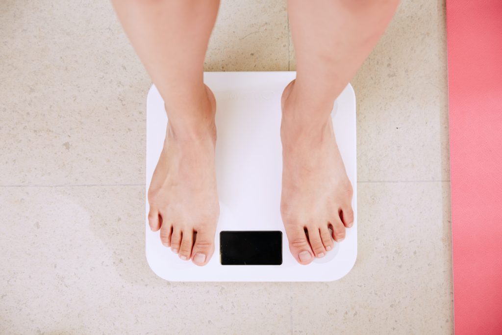 Woman standing on white scale taking her weight