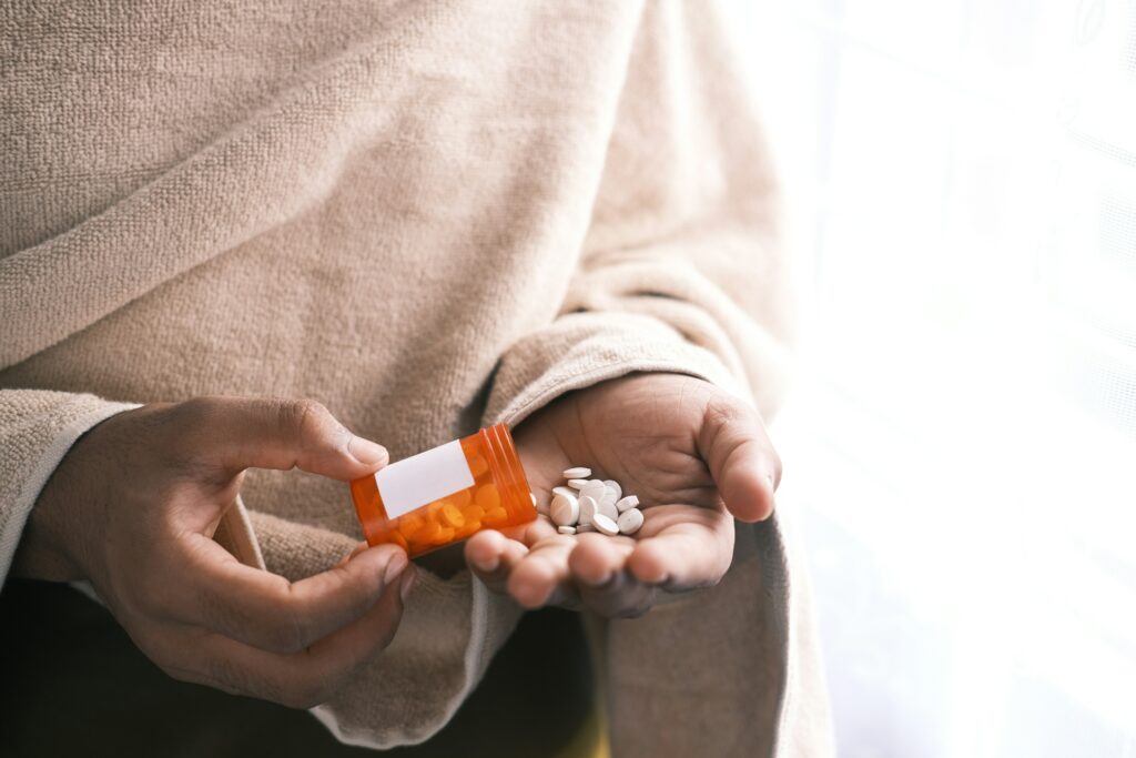 Woman holding bottle of pills in hand